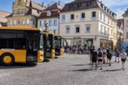 3 goldene Setra-Busse vor der Innenstadt-Kulisse