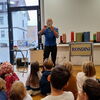 Auf dem Bild ist der Zauberkünstler Rondini bei einem Auftritt im Südstadttreff zu sehen, im Vordergrund sitzen Kinder die ihm zuschauen.