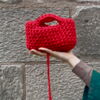 Eine rote gehäkelte Handtasche.