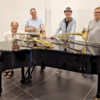Die Musiker stehen an einem Flügel. Auf dem Flügel liegen verschiedene Musikinstrumente.