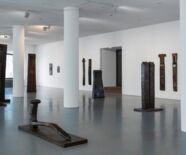 Blick in die Ausstellung, vorne: Liegende Figur/sich aufrichtend, 1991, Holz, Eisen, L 200 cm. Foto: Frank Kleinnbach