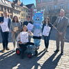 Zu sehen sind die Akteure der Turni Tobe Halle mit Traktor, Steckenpferd und Mistgabel mit Plakaten in der Hand haltend vor dem Gmünder Rathaus.