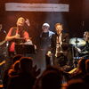 Die Band beim spielen auf einer Bühne.