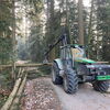 Zu sehen ist ein  Zangenschlepper der die Stämme am Wegesrand für den Abtransport bereit legt.
