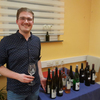 Zu sehen ist Kevin Kärcher mit einem Glas Wein