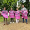 Zu sehen sind die Projektbeteiligten des Theaterprojekts im Innenhof des Spitals stehen, mit den Plakaten in der Hand haltend